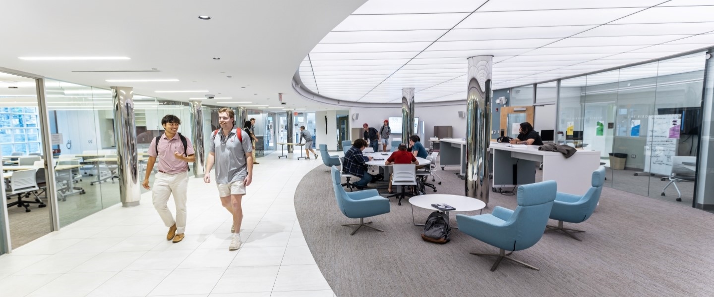 Students walking through the glass-walled, bright atrium of the Rhetoric Center