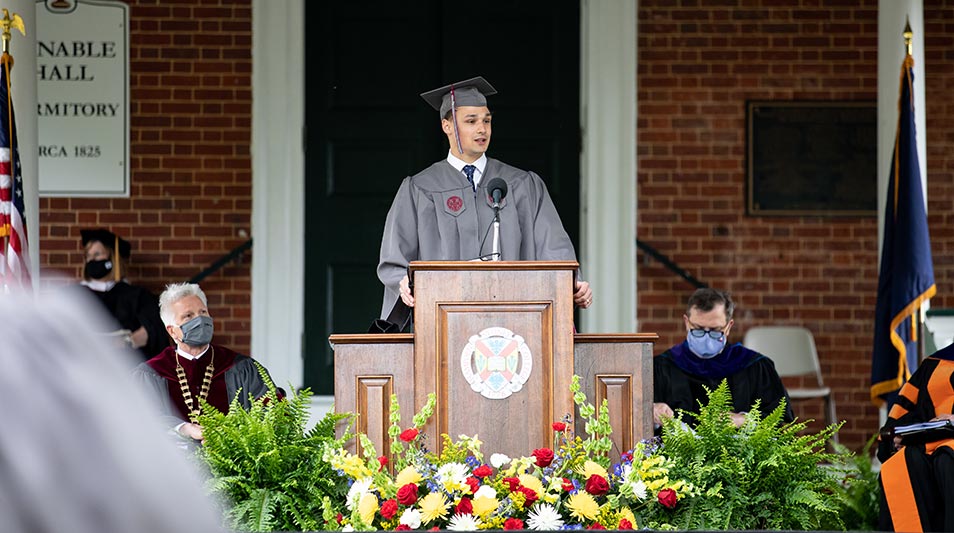 Student delivering remarks at the podium at commencement