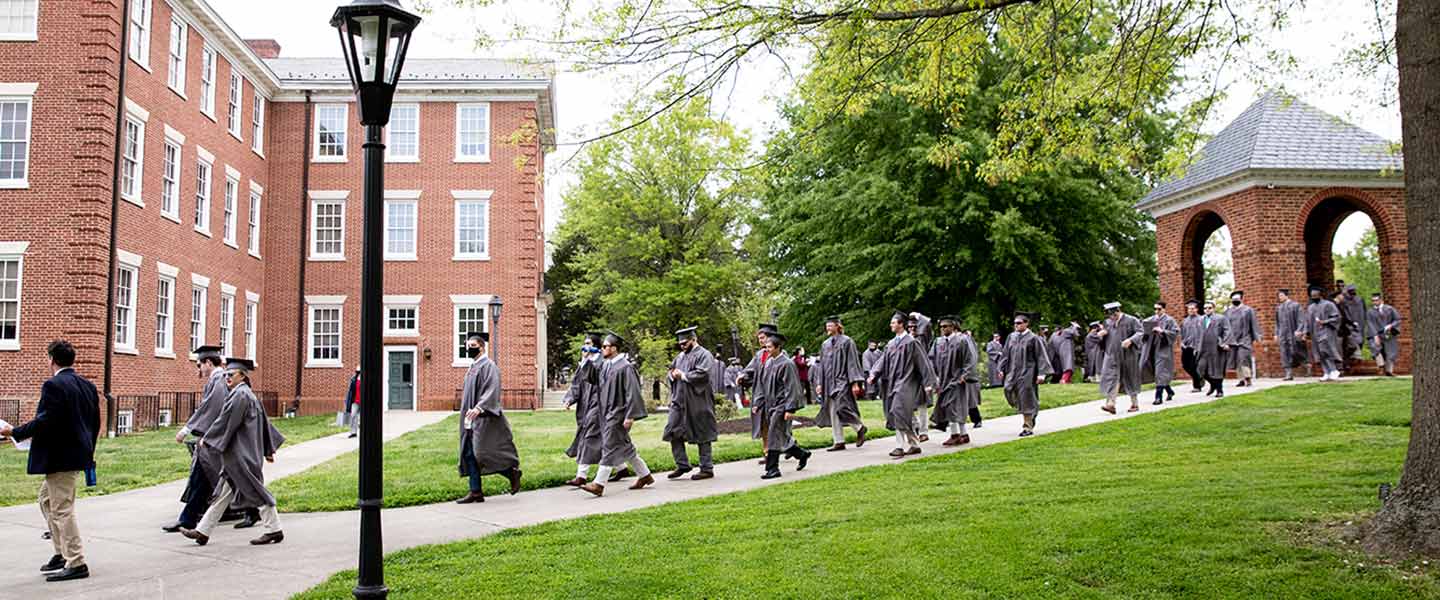 graduates in regalia processing from the Bell Tower
