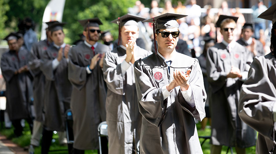 students in regalia giving a standing ovation