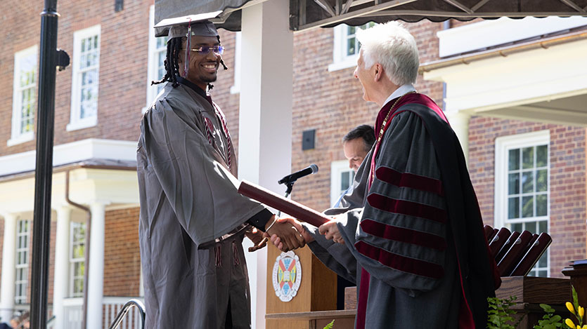 a graduate receiving his degree from the College proesident