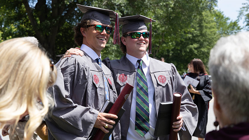 graduates posing and smiling together after commencement
