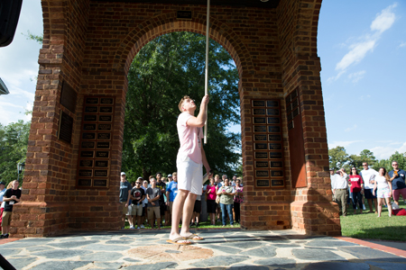 A student rings the bell during Orientation