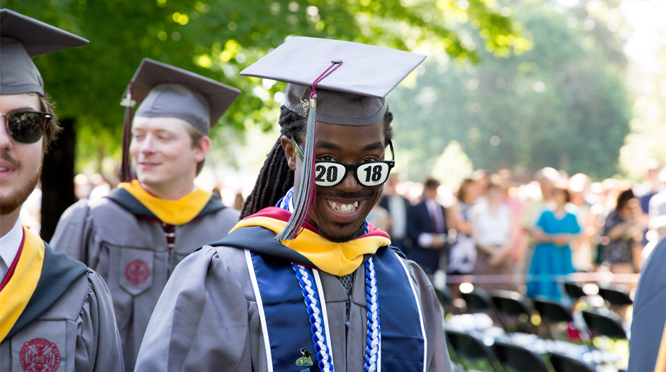 A graduate smiles in his 2018 garb.
