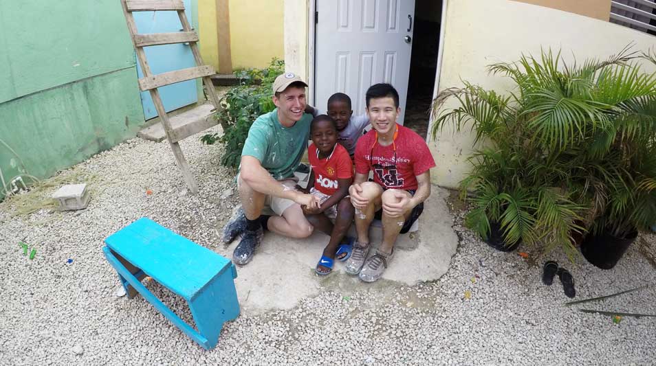 Tanner Beck ‘18 and Jacky Cheng ‘18 with children in a yard on an education service trip