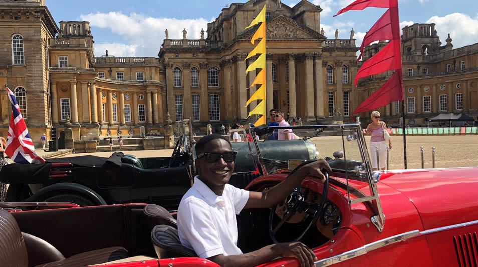 Alex Chalgren '21 sits in a Bentley in front of Blenheim Palace.