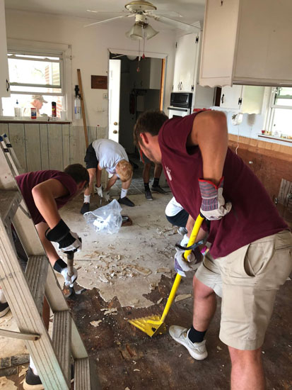 Students scrape flooring.