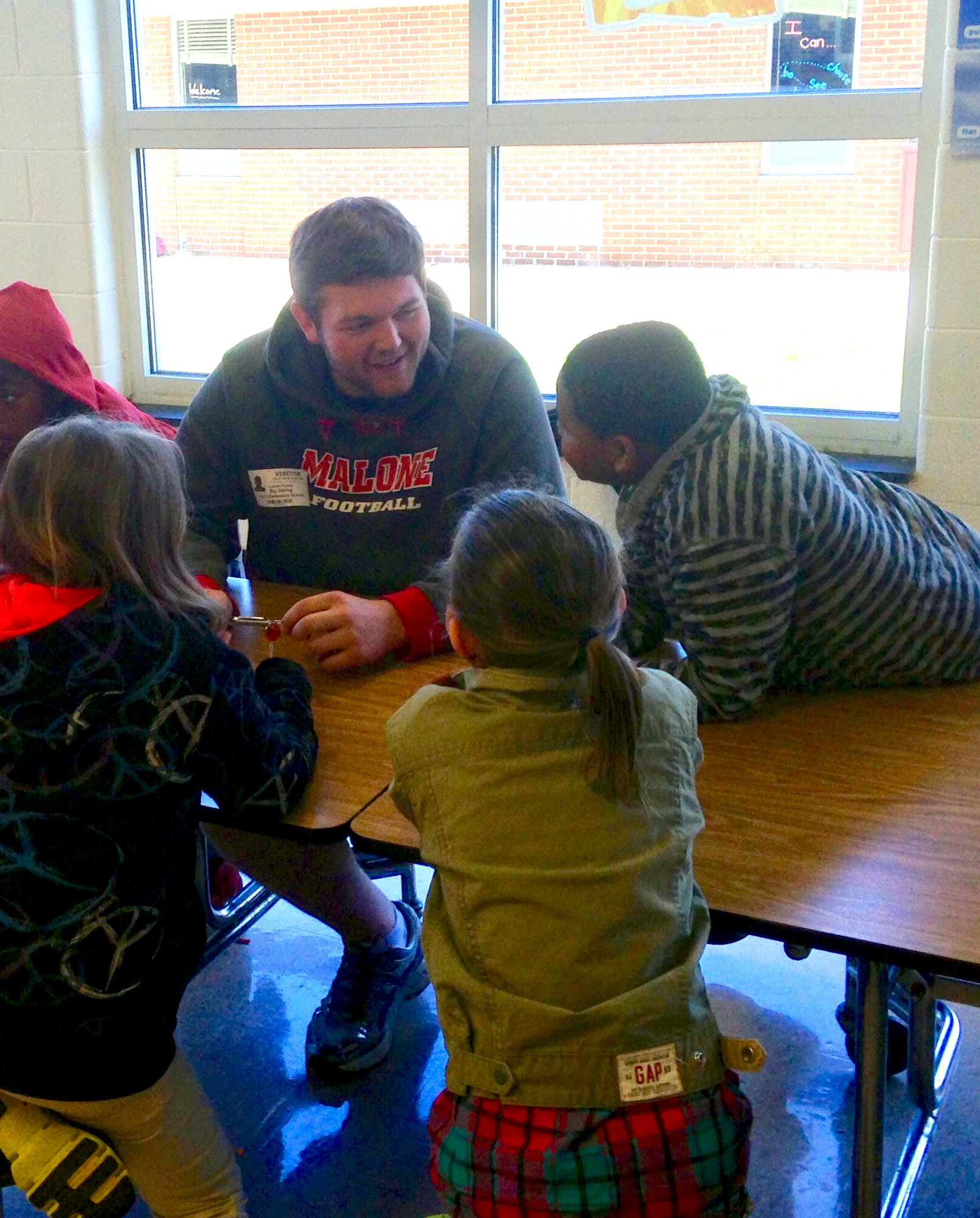 A mentor works with Prince Edward Elementary students at lunch.