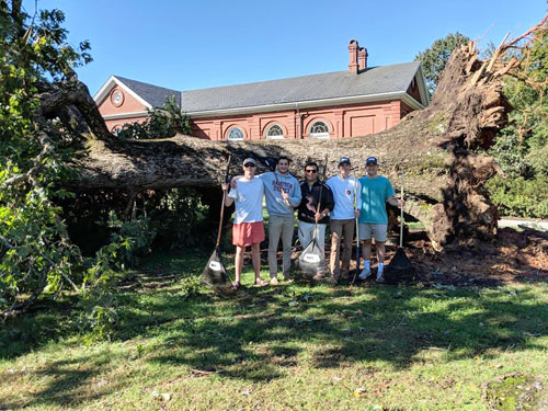 Hampden-Sydney student leaders standing in front of a downed tree in front of Winston Hall