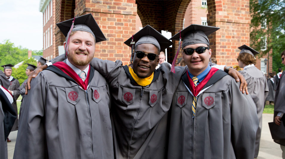 Three graduates pose for a group photo.