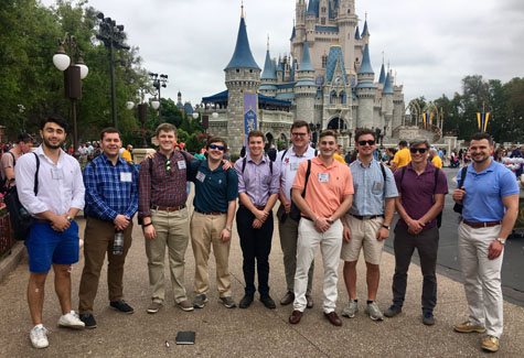Students pose in front of the Magic Kingdom in Disney.