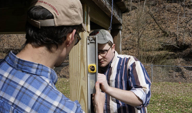 Two students use a level to line up stairs on their construction project in WV.
