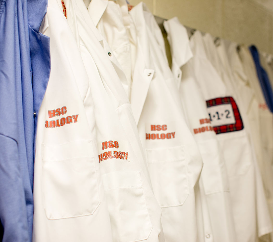 labcoats hanging on a rack