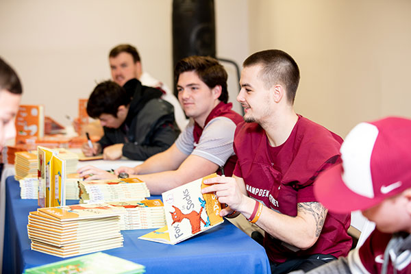 Hampden-Sydney students signing Dr Seuss books for children