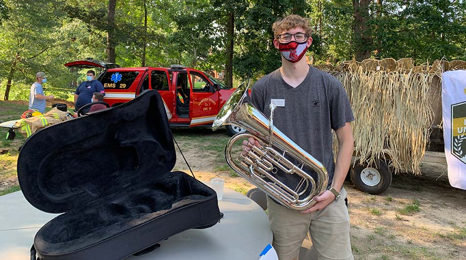 a student holing an instrument at activities fair