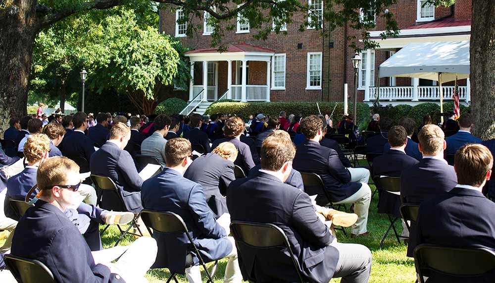 the backs of seated students atending opening convocation on Venable Hall lawn