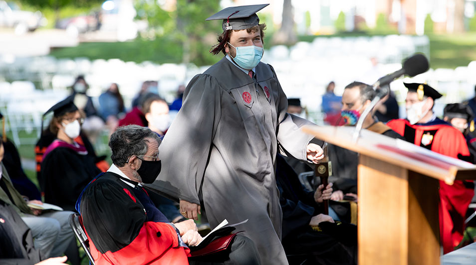 Hampden-Sydney student in regalia walking down the aisle