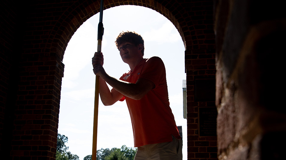 A students ringing the bell in the Watkins Bell Tower