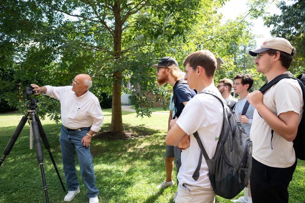 Brian Grogan ’73 showing students photography techniques outside a building at Hampden-Sydney College