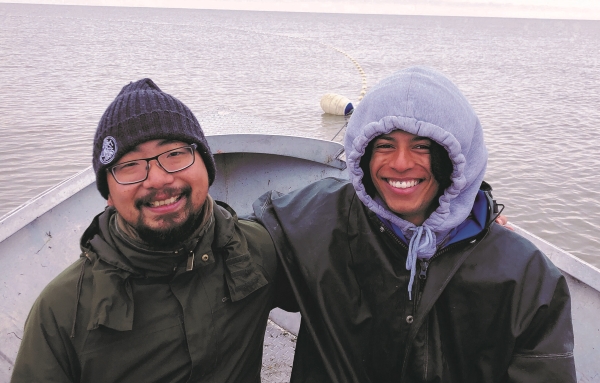 Students smiling on a boat in the ocean