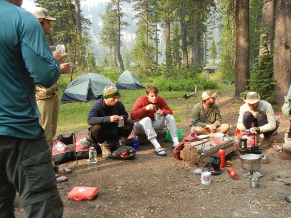 H-SC students eating around a campfire in the Idaho wilderness