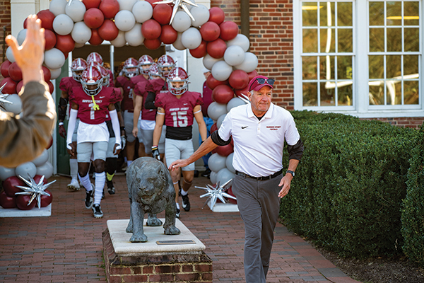 Coach Favret followed by his football team