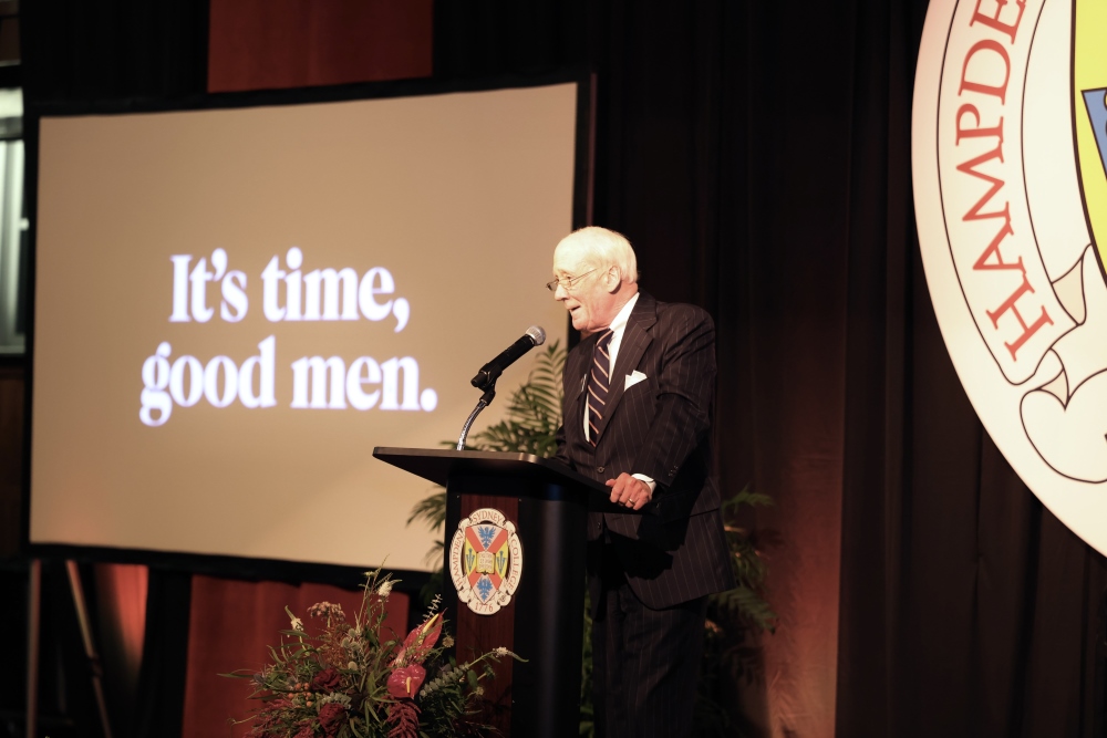 Dr. Eugene Hickock standing at a podium making an announcement to Hampden-Sydney College