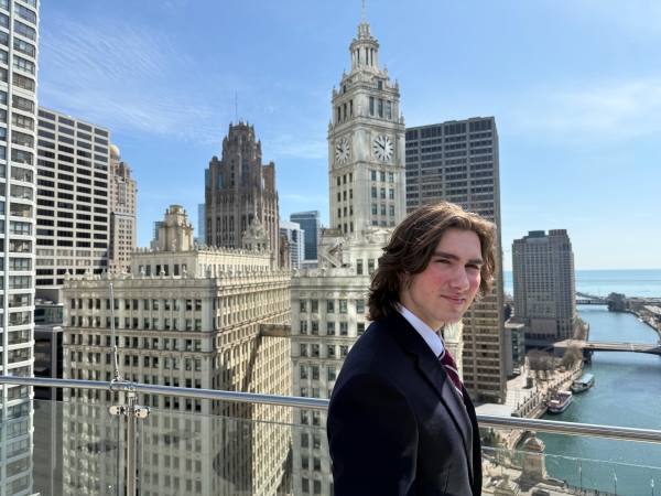 student standing in front of a chicago skyline at a conference