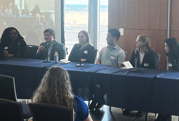 student sitting on a panel at a conference