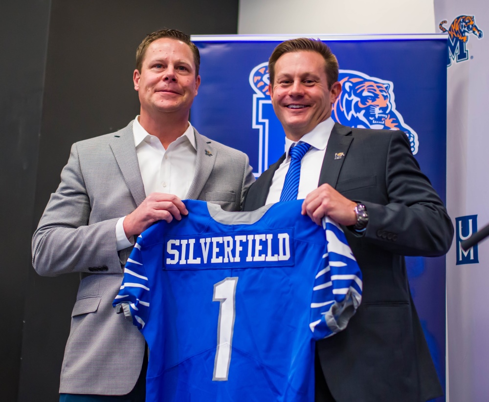 Coach Ryan Silverfield holding a football jersey