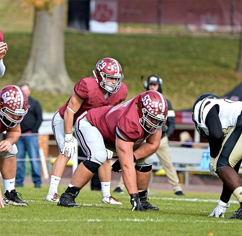 Tyler Howerton '21 in uniform playing on the football field