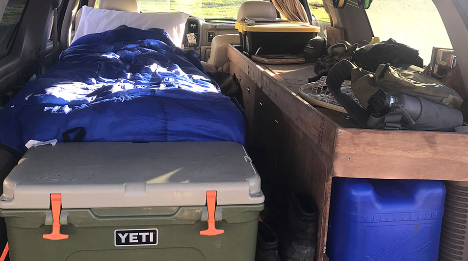 The trunk of a Suburban loaded with fishing gear