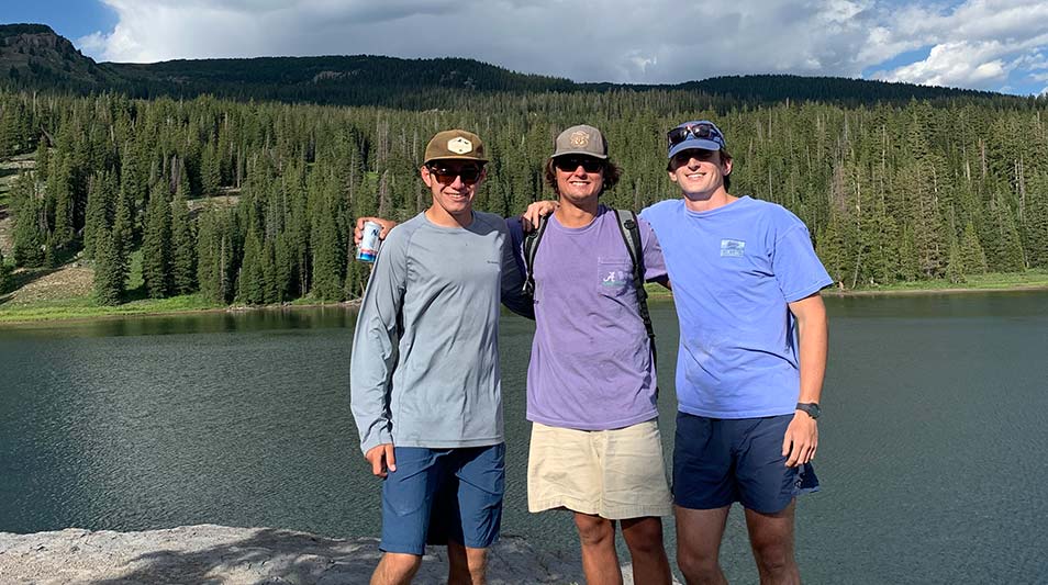 David King III '21 Joel T Williams '21 Billy Wilson '21 in front of a river