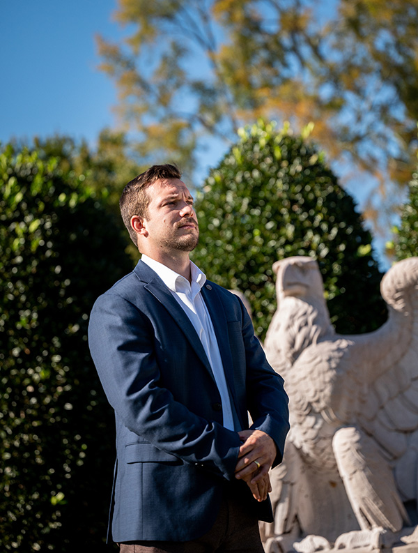 Mike Daum '23 gazing in front of a statue of an eagle