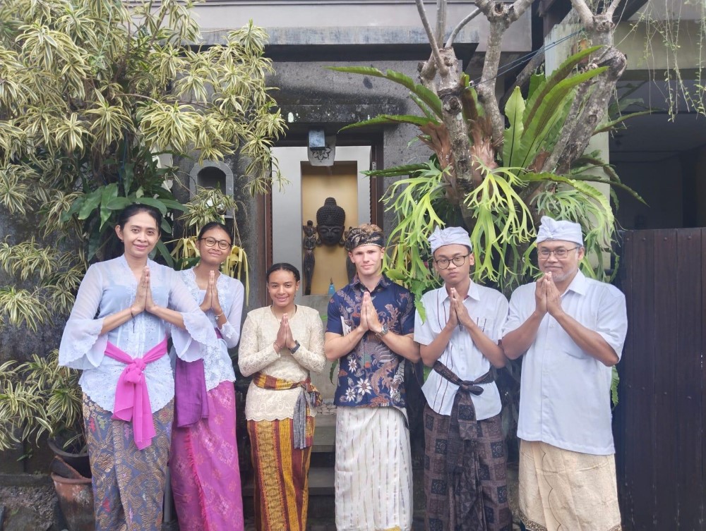 Jack Thomas '25 standing in the center of an Indonesian family for a photo in Bali