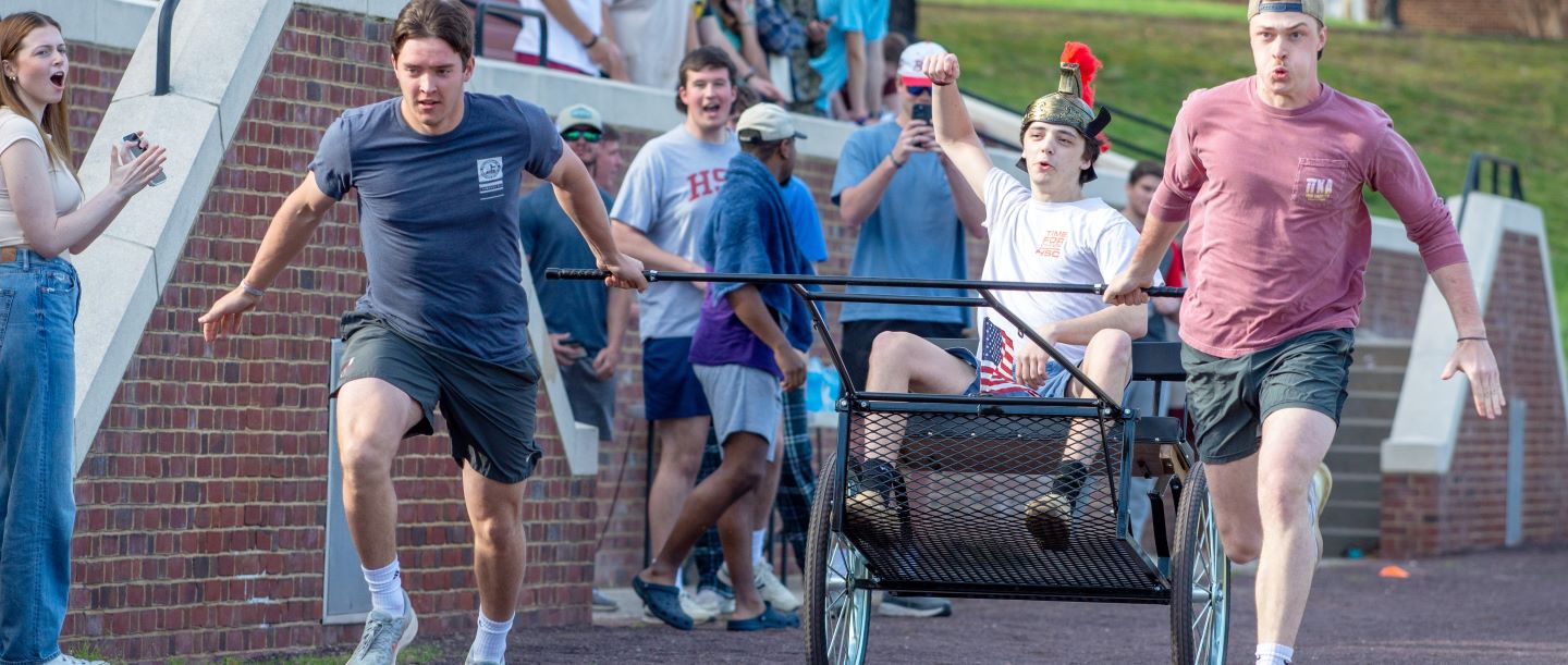 Brothers of a fraternity running in a chariot race at Hampden-Sydney College