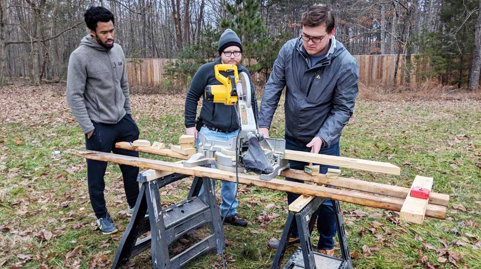Hampden-Sydney student volunteers cutting wood for a Habitat for Humanity home
