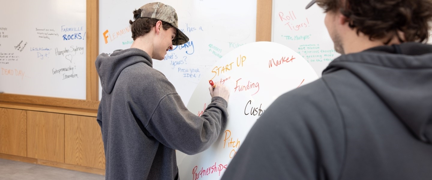 Students writing business plans on a white board