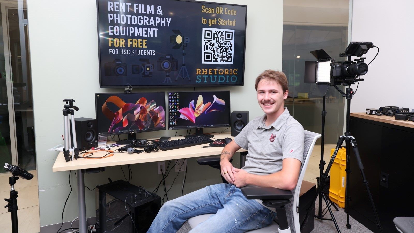 Student Haden VonCanon sitting at an audio visual desk in the Rhetoric Studio