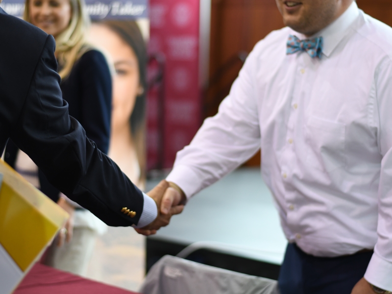 a close-up of  two men extending a handshake