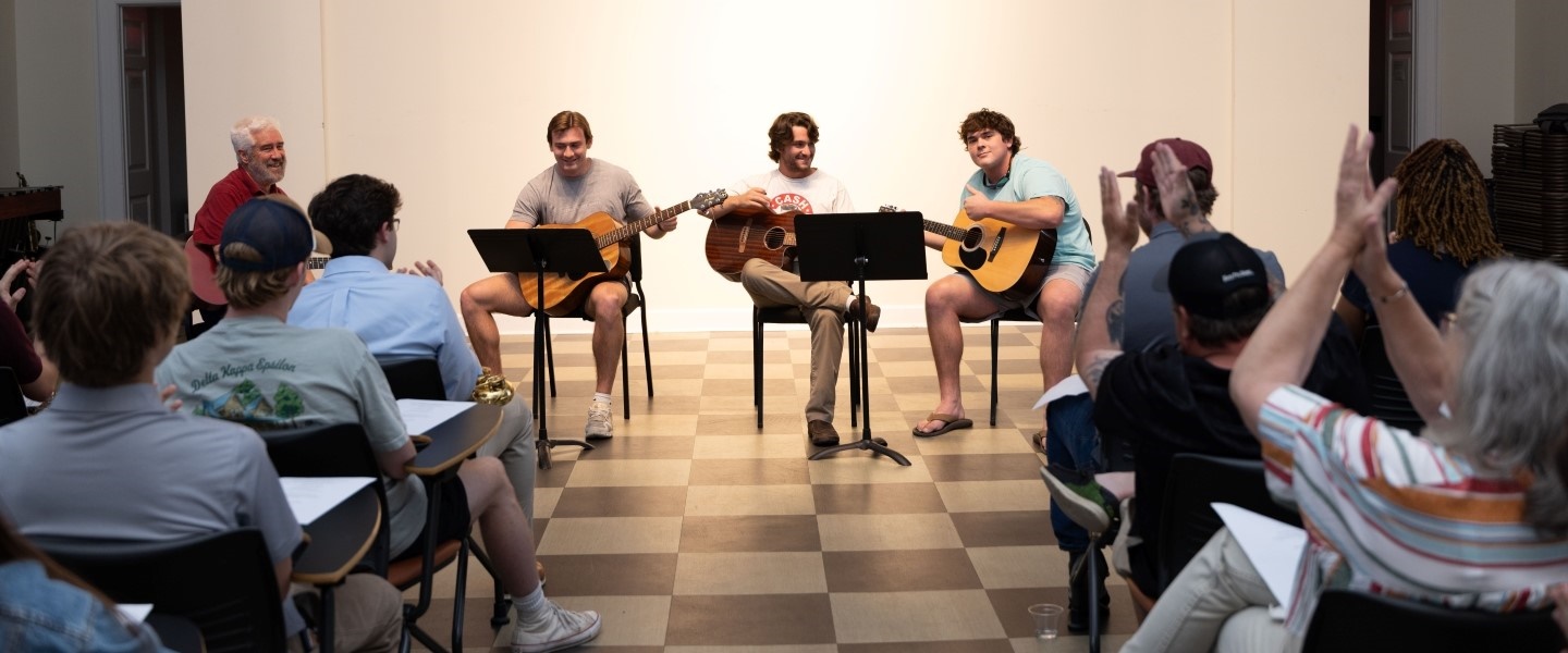 ensemble of students playing guitar at their final performance