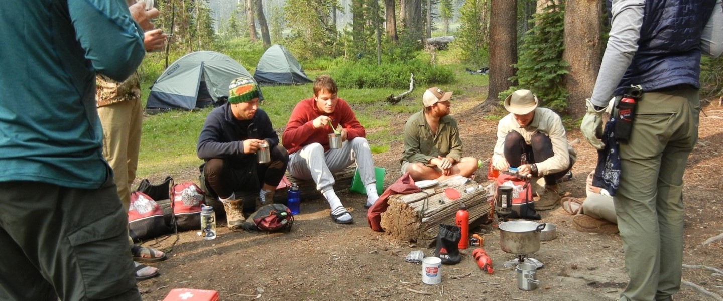 students hanging out in their campsite in the Idaho Wilderness