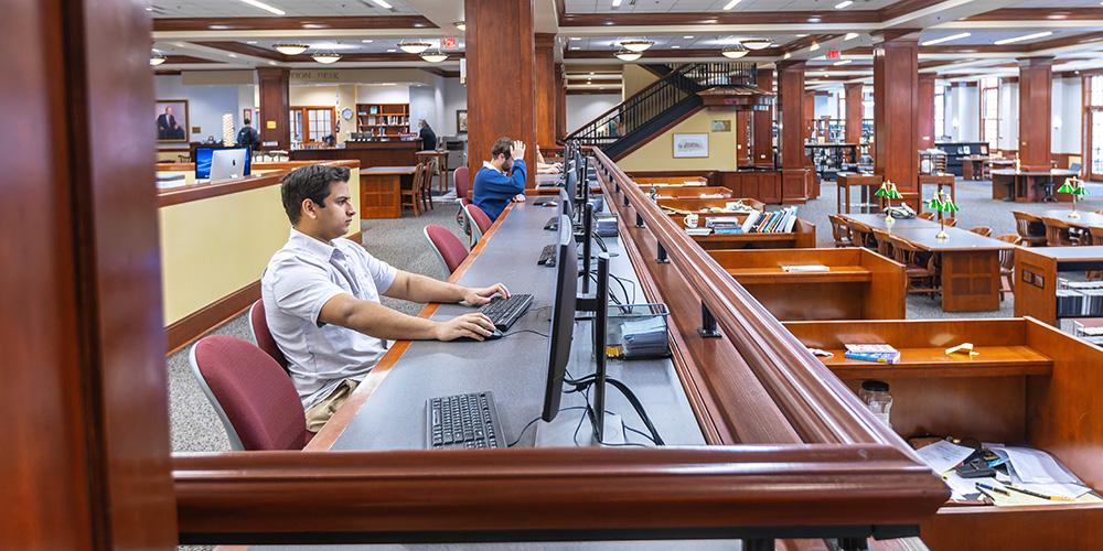 a student sitting at a computer in the library