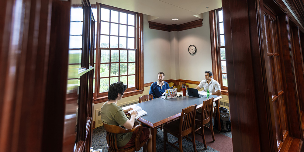 students gathered at a table in discussion