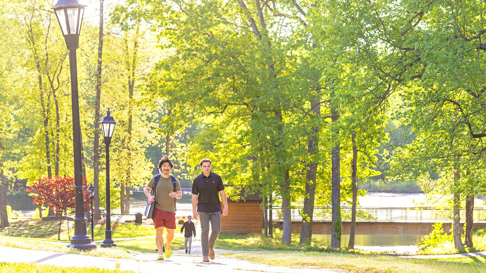 students walking on a bright spring day near Chalgrove Lake
