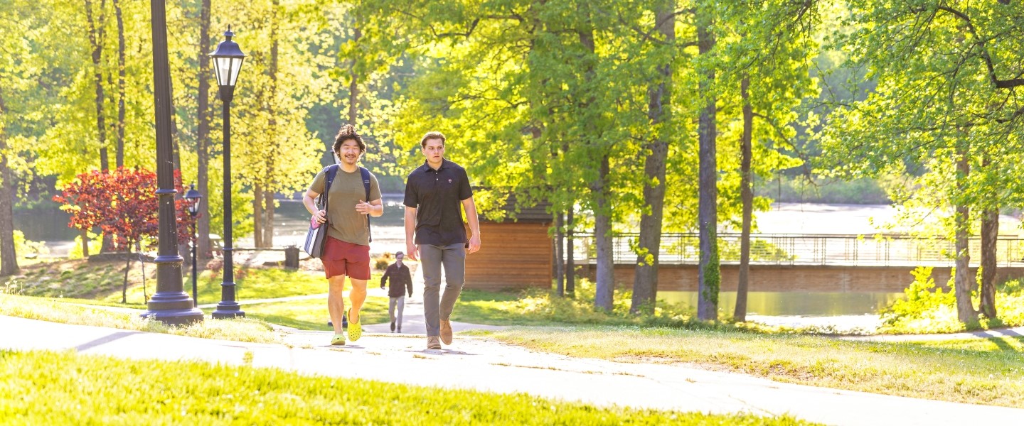 students walking along Chalgrove Lake in the spring