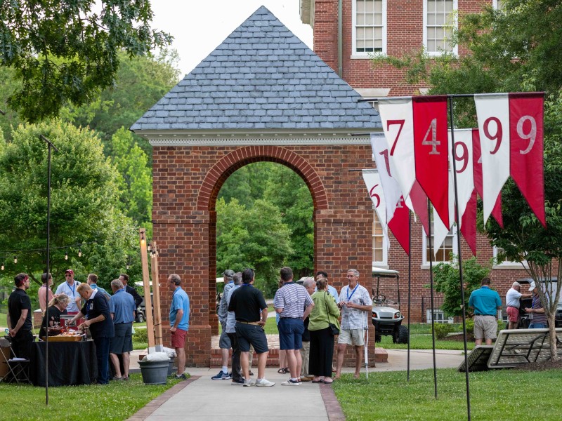Alumni and families gathering around the Bell Tower