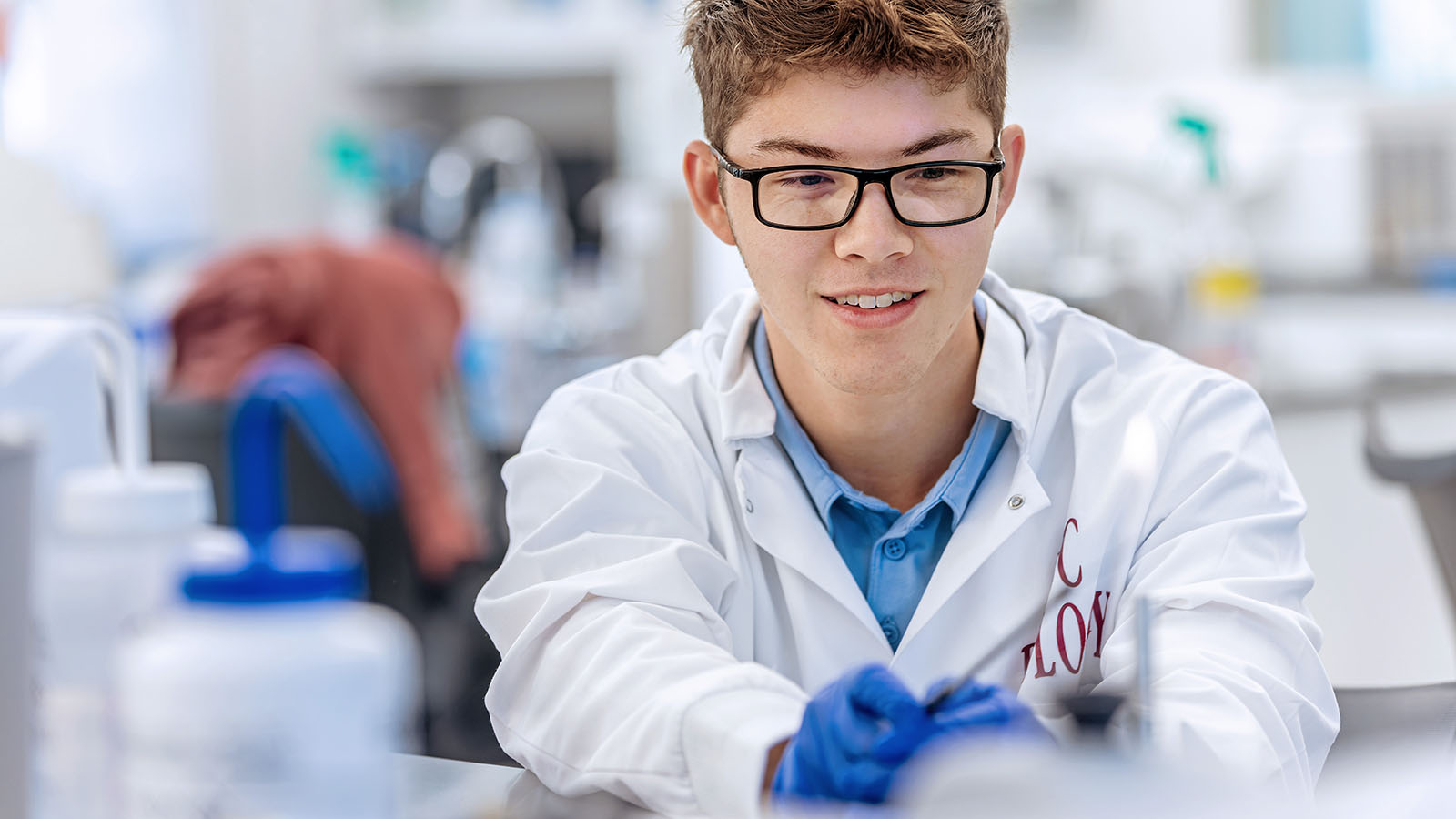 a student in a laboratory coat doing research