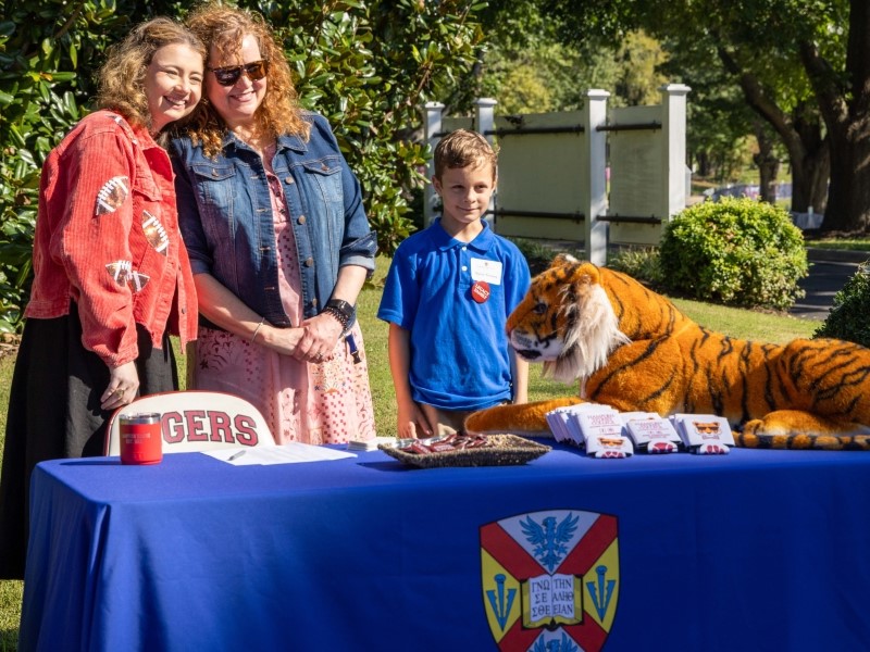 parent engagement staff standing at a table during family weekend