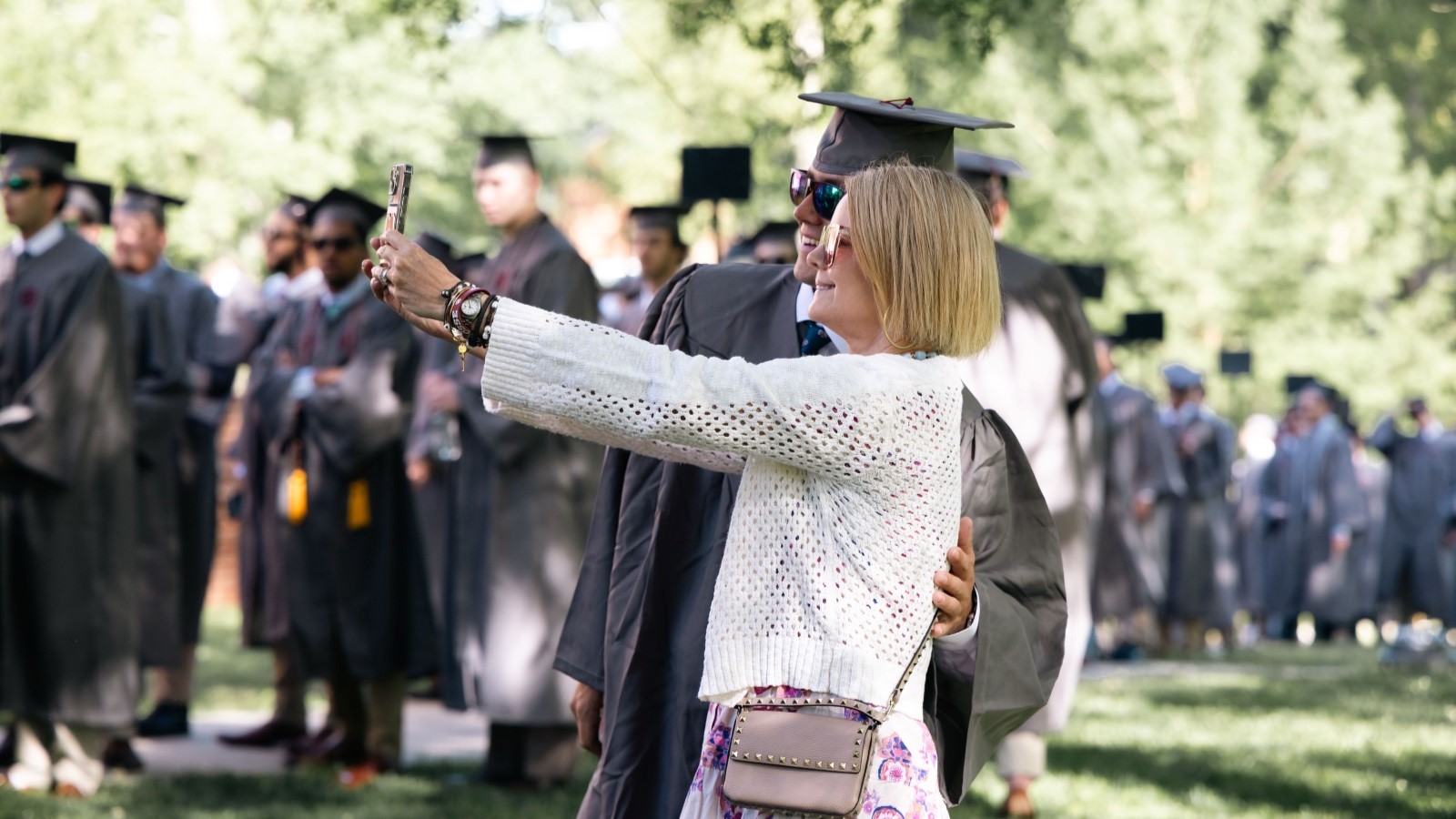a mother and son posing for a selfie at commencement